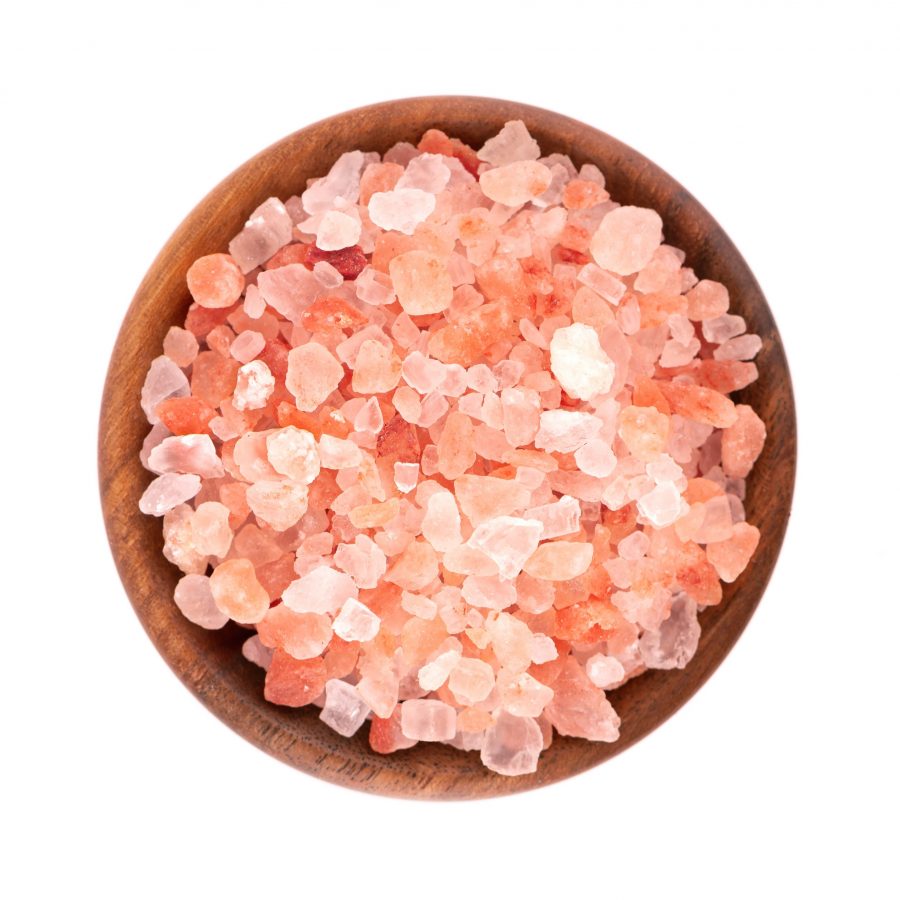 Himalayan pink salt in wooden bowl, isolated on white background. Himalayan pink salt in crystals. Top view